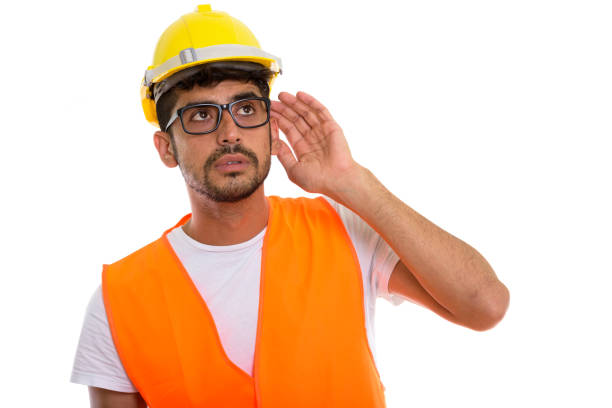 istock Studio shot of young Persian man construction worker listening while thinking and looking up 670472496