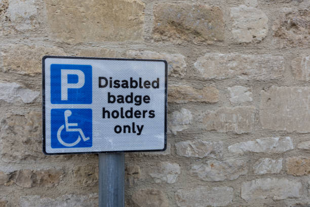 istock disabled or handicapped badge holder parking sign, against stone wall 670481212