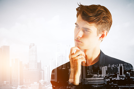 Thoughtful young businessman on abstract city background. Double exposure