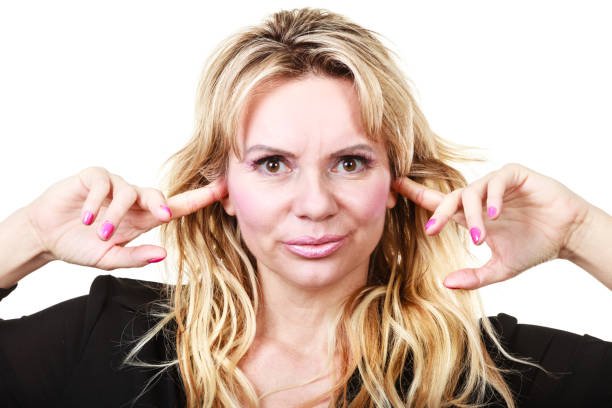 istock Blonde woman plug ears 670495180
