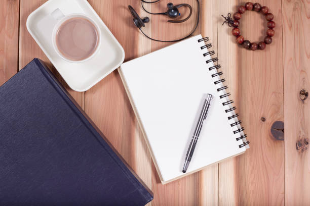istock white notebook  on wood table with coffee in morning. 670498252