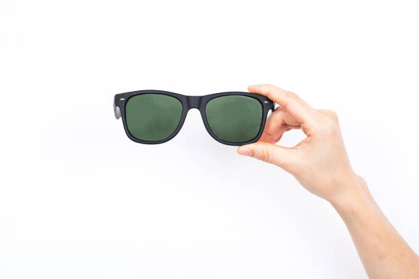 istock Hand holding pair of sunglasses on white background. 670498312