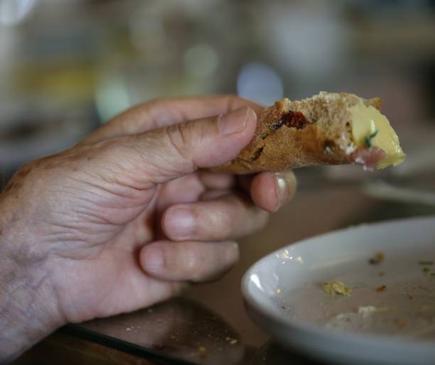 istock Aged Man Hand Holding a Bread Slice With Omelette. 670498916