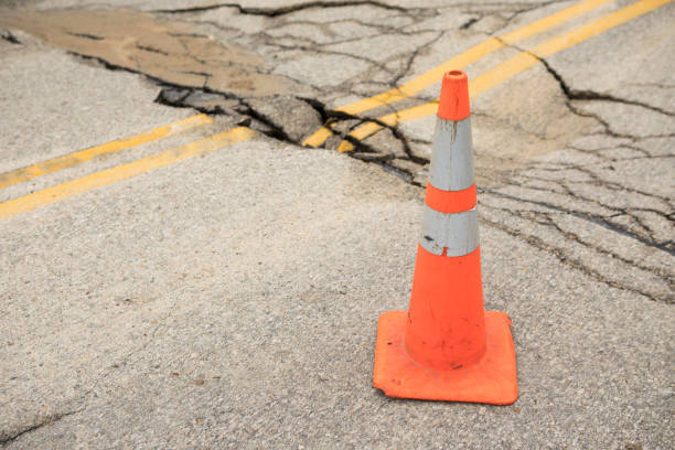 istock Broken Up, Cracked Road Asphalt with Safety Traffic Cone 670510698