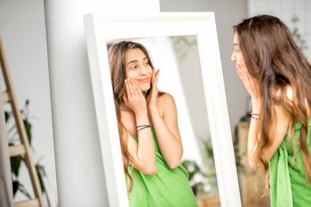 istock Woman looking at mirror in the bathroom 670514424