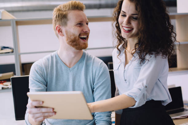 istock Happy business colleagues in modern office using tablet 670517912