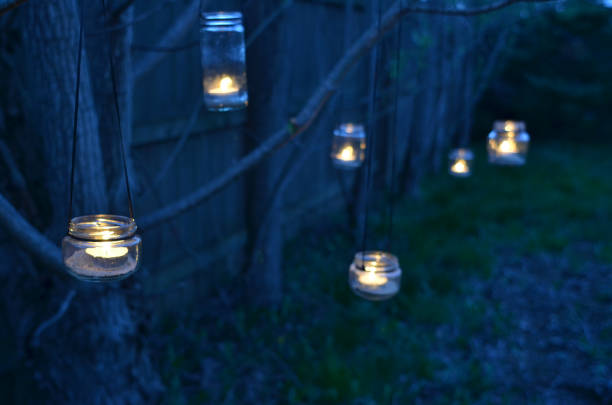 istock night scene candles in jars hanging on tree branches 670520210