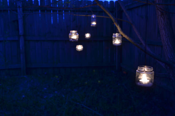 istock night scene candles in jars hanging on tree branches 670523804
