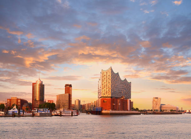 Hambirg, view on the Elbe river towards Elbphilharmonie at sunset HANBURG, GERMANY- AUGUST 12, 2015: Hambirg, view on the Elbe river towards Elbphilharmonie, a concert hall in the Hafen City at sunset. elbphilharmonie photos stock pictures, royalty-free photos & images
