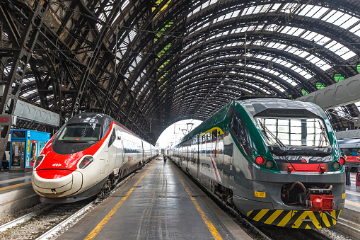 MILAN, ITALY - JUNE 14, 2016: Train SBB (Left) and Trenord companies on platforms of the Milan Central Railway Station (Milano Centrale). It is the main railway station of Milan, Italy. Opened in 1931