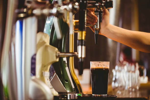 istock Cropped hand of bartender dispensing beer 670536630
