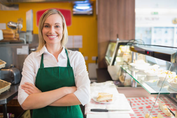 istock Confident female shop owner standing by display cabinet 670537534