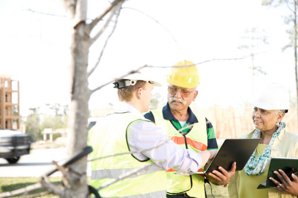 istock Multi-ethnic team of construction engineer, architect and worker at job site. 670539932