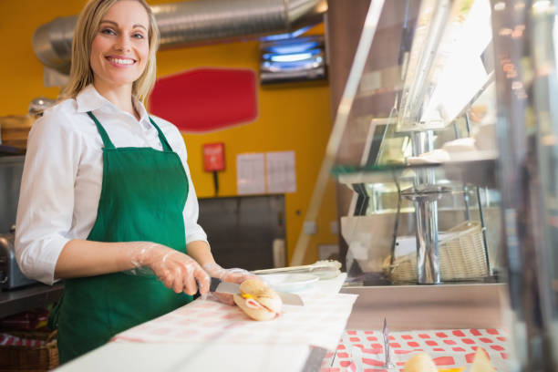 istock Female worker cutting sandwich on counter 670539994