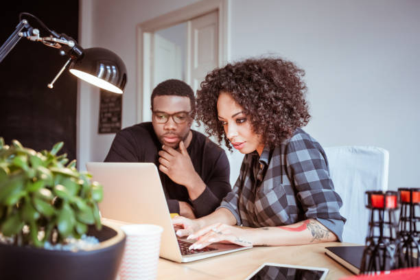 istock Two young designers in the office using laptop 670540094