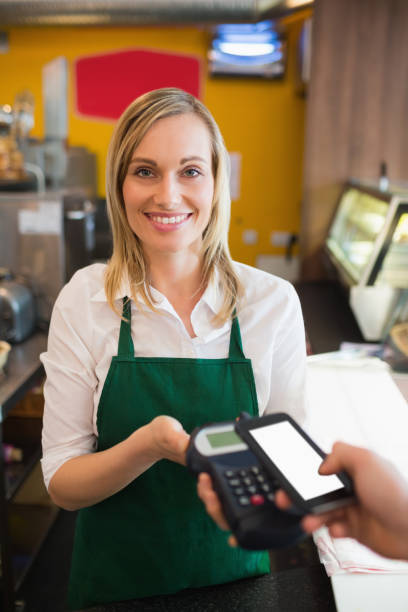 istock Portrait of female worker accepting payment through NFC 670540840