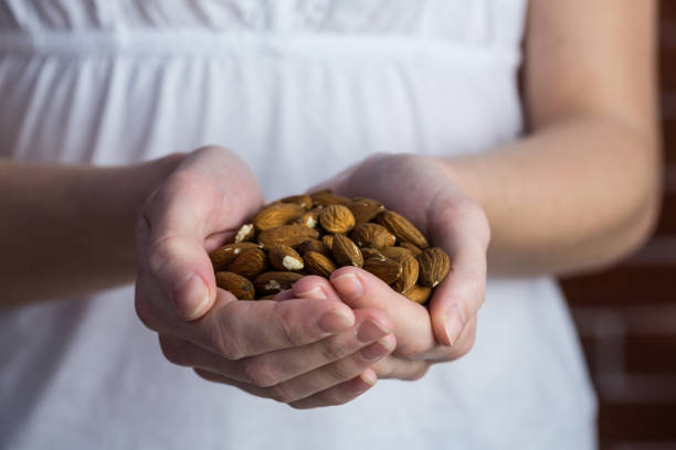 istock Woman showing handful of almonds 670544108