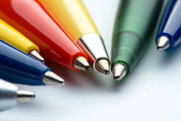 Office: Ballpoint pens in various colors Macro shot of  ball point pens in a row in various colors on white background ballpoint pen photos stock pictures, royalty-free photos & images