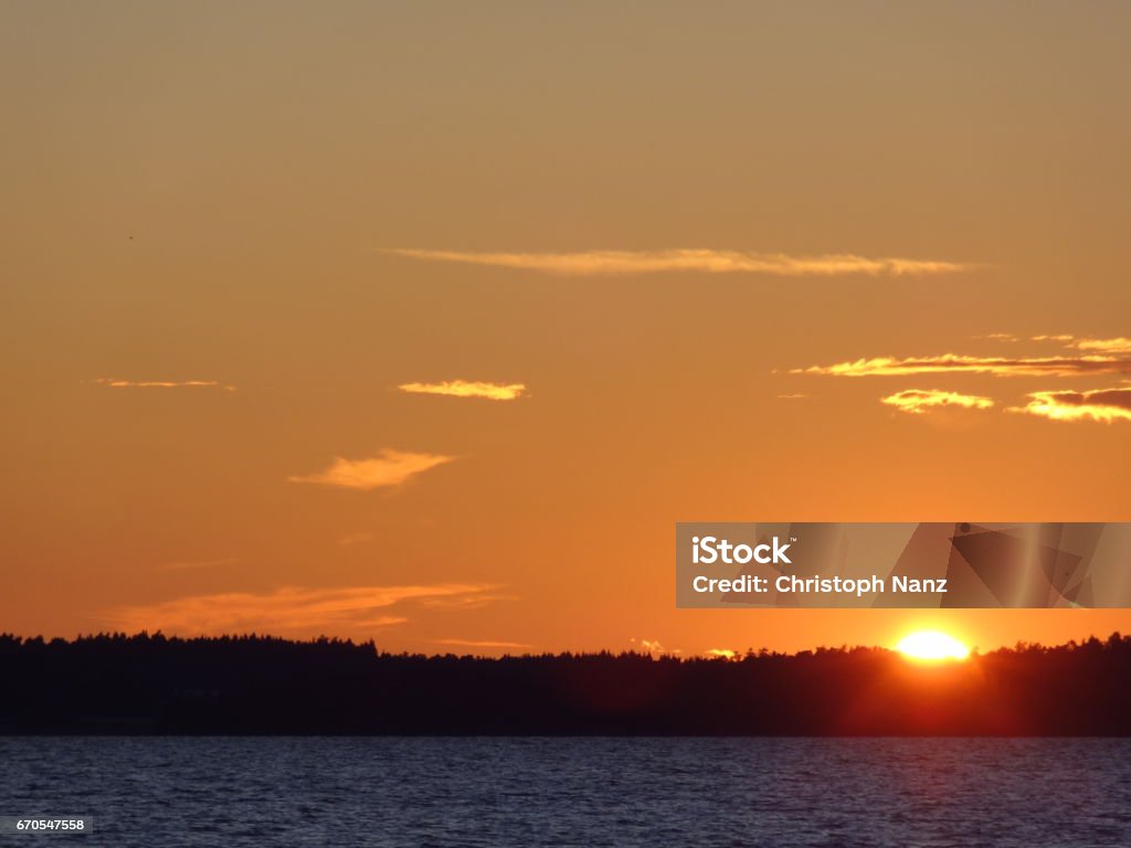 Red horizon with clouds and sunset over the Vättern in Sweden Beautiful sunset in Sweden Beach Stock Photo
