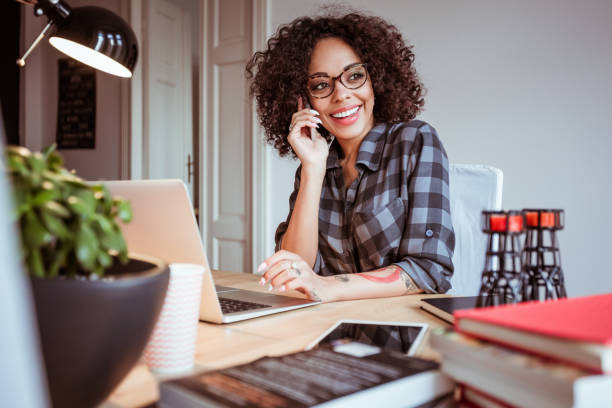 istock Young woman making a phone call from home office 670550144