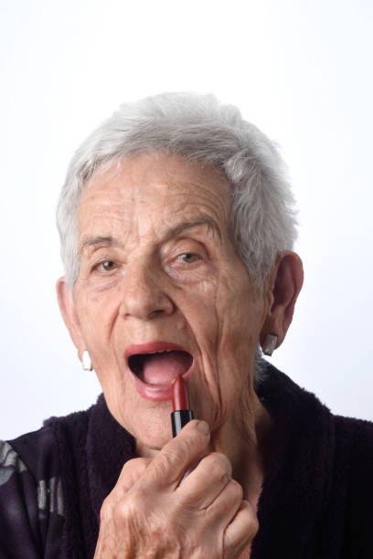 stara kobieta maluje usta na białym tle - female 80 plus years vertical people zdjęcia i obrazy z banku zdjęć