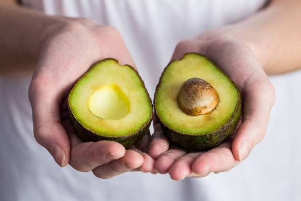 istock Woman showing fresh avocado 670557446