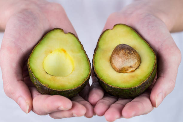 istock Woman showing fresh avocado 670557526