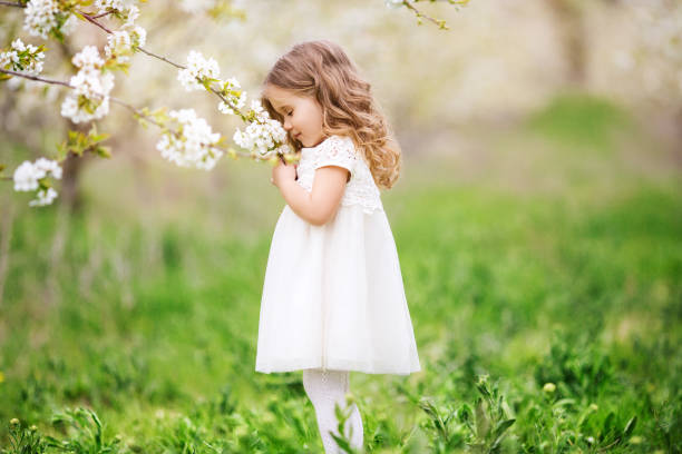 Pretty child girl in blossom garden stock photo