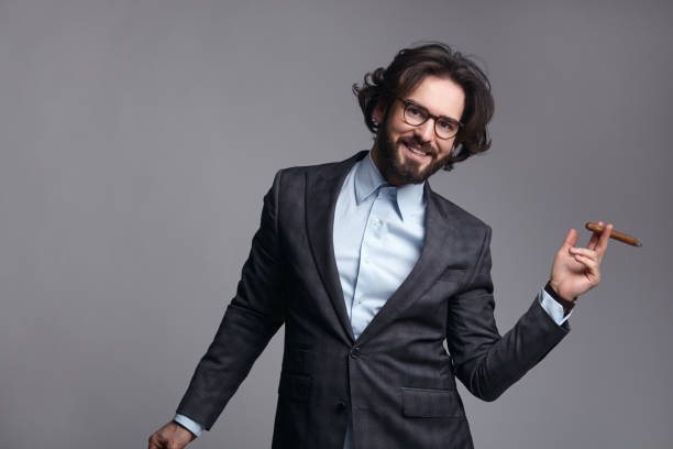 istock Smiling young male in suit with cigar 670570524