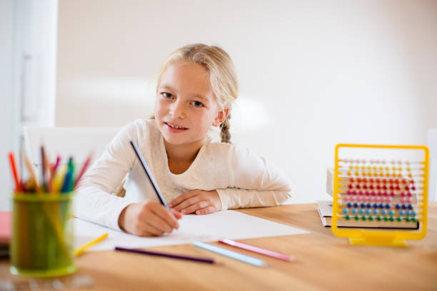 istock Beautiful blond girl doing homework 670578018
