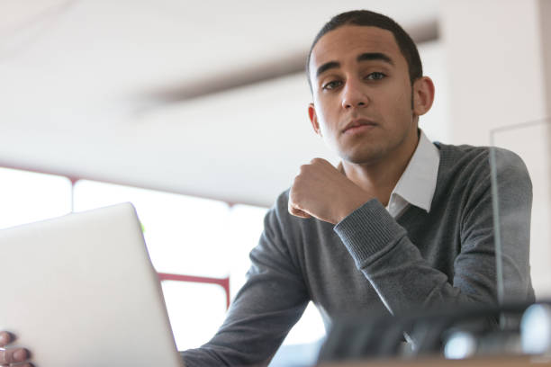 istock Serious man in office with laptop 670578588