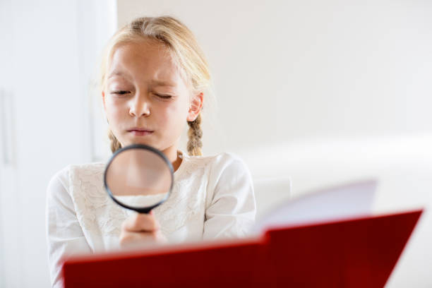 istock Blond girl kid reading through spyglass 670578614