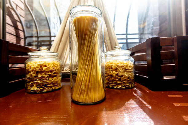 Banks with Italian pasta on the background of the window in retro style.