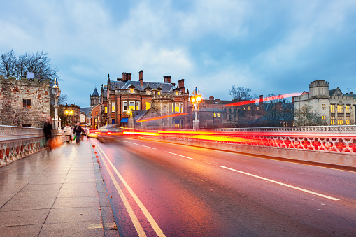 Stock photograph of people and cars crossing bridge over River Ouse in downtown York, England, United Kingdom.