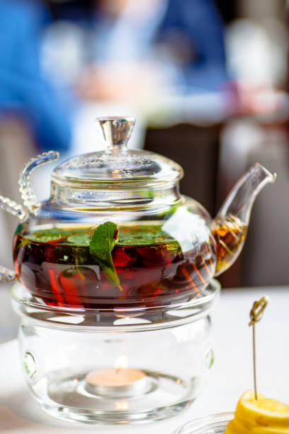 istock Tea with mint leaves in a glass teapot with a candle. 670584628