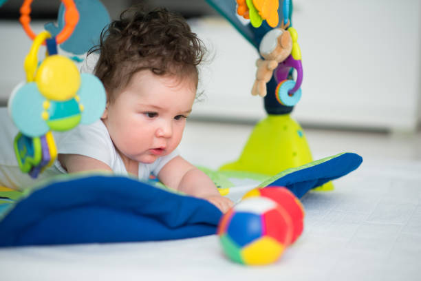istock Baby boy playing, trying to reach ball 670587776