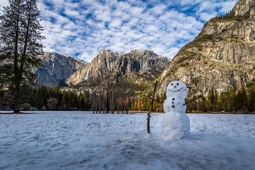 Snowman at Yosemite Valley during winter with Upper Yosemite Falls on background - Yosemite National Park, California, USA