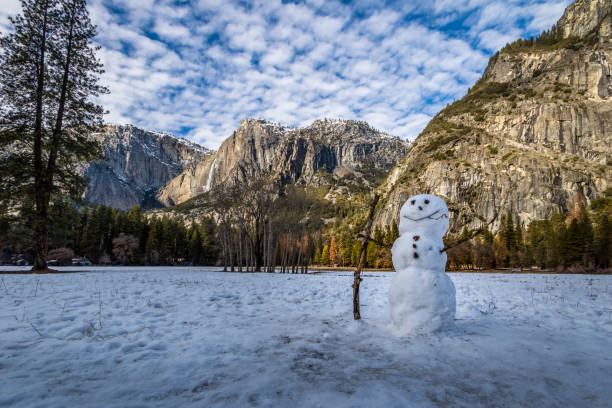 boneco de neve no vale de yosemite, durante o inverno com upper yosemite falls em fundo - parque nacional de yosemite, califórnia, eua - yosemite national park winter waterfall california - fotografias e filmes do acervo