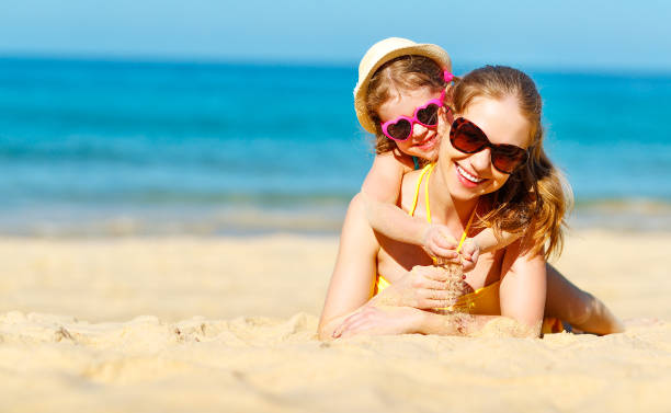 счастливая семья мать и дочь ребенка на пляже летом - fun mother sunglasses family стоковые фото и изображения