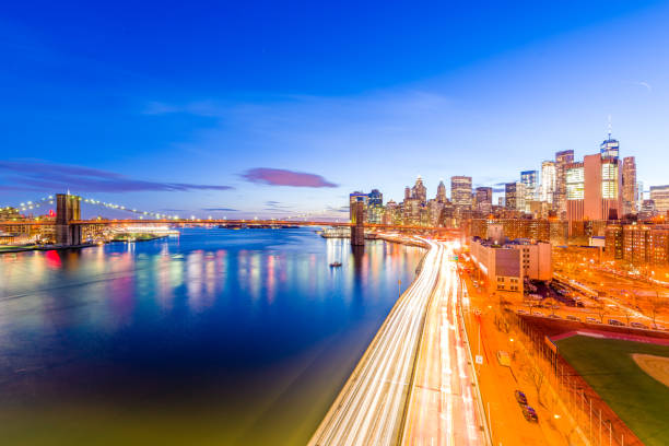 Rushing to the lower Manhattan Cars are driving on the FDR drive at dusk towards the lower Manhattan. The Brooklyn Bridge, the East river and the One World Trade Center can be seen. new york marathon photos stock pictures, royalty-free photos & images