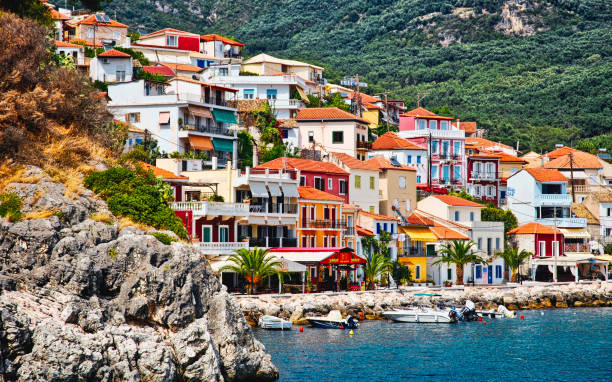 Parga, Greece hillside town View of hillside homes and buildings set between a rocky outcrop and green mountain background.  Colourful homes spilling down the hillside  towards the ocean. View approaching by boat parga greece stock pictures, royalty-free photos & images