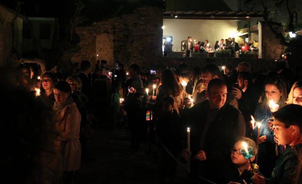 Greek Orthodox Easter Vigil Peloponnese, Greece - 15th April 2017: Greek Orthodox pilgrims holding candles with the Holy Light celebrating Jesus Christ Resurrection on Good Saturday midnight service in Monemvasia Kanoni square sparta greece photos stock pictures, royalty-free photos & images