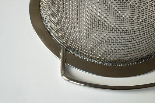 Detail of small kitchen colander cullender on white