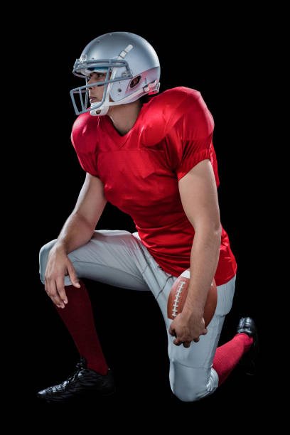 istock American football player looking away while kneeling 670621650