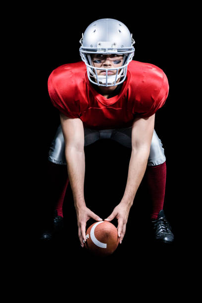 istock American football player bending while holding ball 670622174