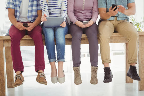 istock Low section of business people sitting on desk 670625638