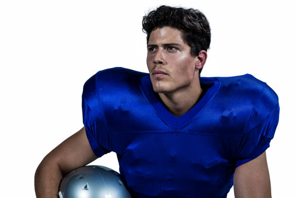 istock American football player holding helmet while looking away 670628174