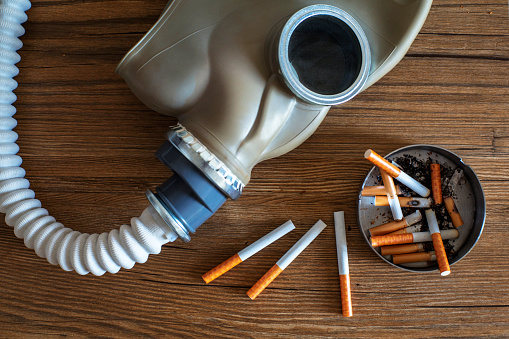 gas mask, cigarette butts in ashtray