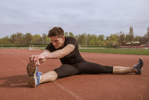 istock one young man, stretching leg, running tracks 670636022