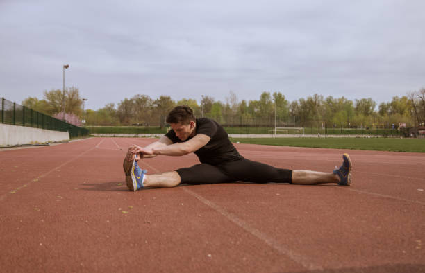 istock one young man, stretching leg, running tracks 670641620
